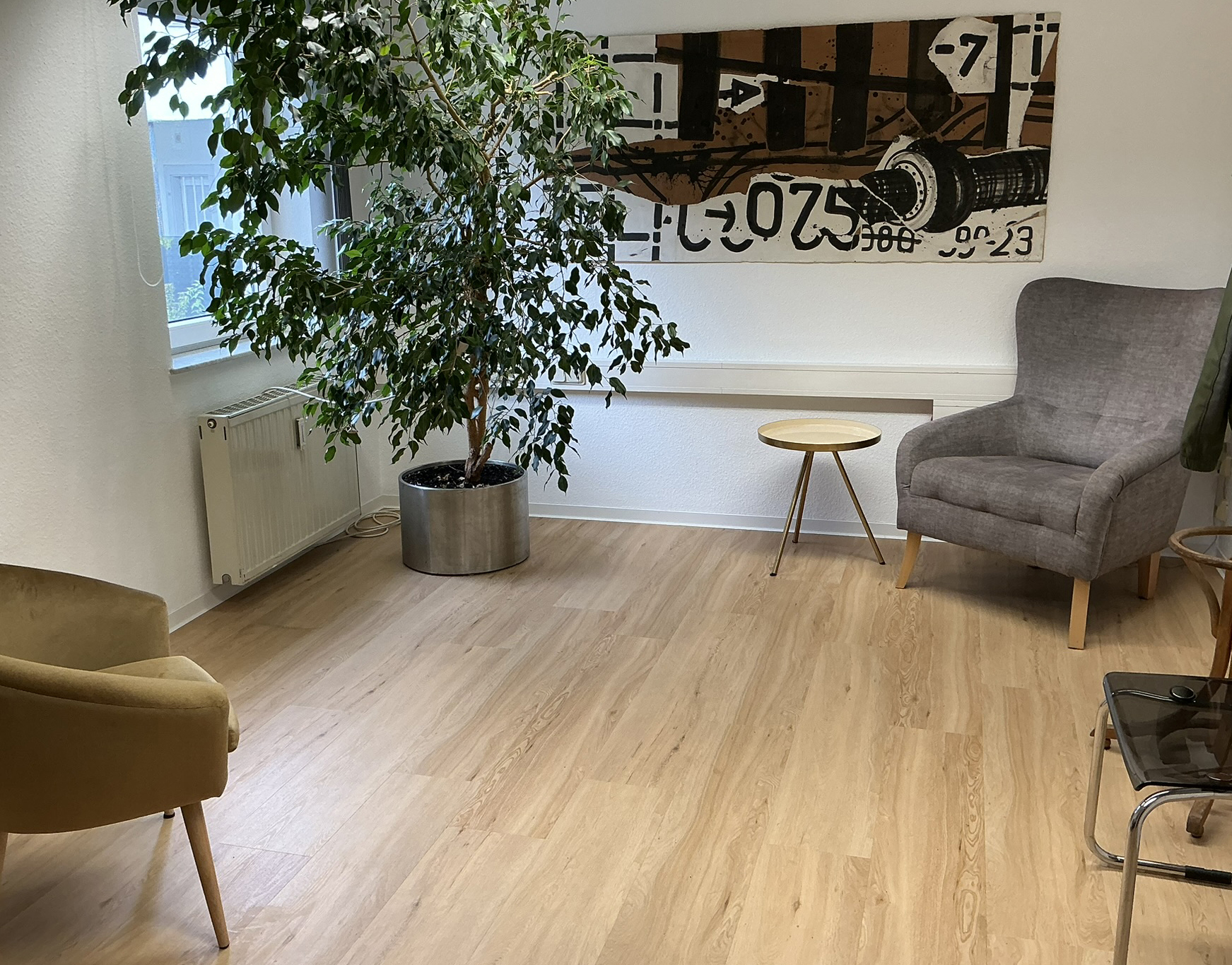 Schöner Praxisraum mit großer Pflanze in Braun und Beigetönen
